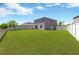 Spacious fenced back yard with healthy green grass and beautiful blue sky at 10142 Golden Wonder Ln, Riverview, FL 33578
