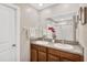 Bright bathroom featuring double sinks, a large mirror, and a walk-in shower at 10142 Golden Wonder Ln, Riverview, FL 33578