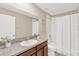 Well-lit bathroom featuring a granite countertop, framed mirror, and shower-tub combo at 10142 Golden Wonder Ln, Riverview, FL 33578