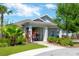 Inviting single-story home featuring a well-maintained lawn, colorful landscaping, and a charming gated entryway at 10142 Golden Wonder Ln, Riverview, FL 33578