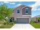 Charming two-story home with gray stucco, a well-maintained lawn, and a spacious two car garage at 10142 Golden Wonder Ln, Riverview, FL 33578