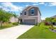 Two-story home featuring a neutral color palette, manicured front lawn, and an attached two-car garage at 10142 Golden Wonder Ln, Riverview, FL 33578