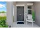Inviting front door with a charming welcome area, including a chair, plants, and a welcoming entrance mat at 10142 Golden Wonder Ln, Riverview, FL 33578