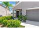 Beautiful front of home with well-manicured landscaping, a palm tree and a cozy front porch at 10142 Golden Wonder Ln, Riverview, FL 33578