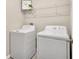 Bright laundry room with washer, dryer, and wire shelf for storage at 10142 Golden Wonder Ln, Riverview, FL 33578