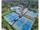Aerial view of tennis courts next to a community pool and ample parking surrounded by mature trees at 10502 Brentford Dr, Tampa, FL 33626