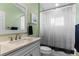 Well-lit bathroom with a white vanity, speckled countertop, and tub-shower with modern fixtures at 10502 Brentford Dr, Tampa, FL 33626