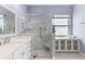 Modern bathroom showcasing glass-enclosed shower, tiled walls, and a built-in shelf for added convenience at 10502 Brentford Dr, Tampa, FL 33626