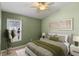 Bedroom featuring green walls, a ceiling fan, and a large window providing ample natural light at 10502 Brentford Dr, Tampa, FL 33626