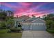 Charming home with a three-car garage, mature landscaping, and vibrant sunset backdrop at 10502 Brentford Dr, Tampa, FL 33626