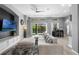 Spacious living room featuring a large sectional sofa and direct access to outdoor pool area at 10502 Brentford Dr, Tampa, FL 33626