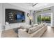 Bright living room with a comfortable sectional, decorative shelving, and a view of the outdoor pool area at 10502 Brentford Dr, Tampa, FL 33626
