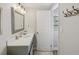 Bathroom with gray vanity, framed mirror, and wood look flooring at 106 W Louisiana Ave, Tampa, FL 33603