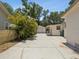Side exterior view featuring a large driveway and detached garage at 106 W Louisiana Ave, Tampa, FL 33603