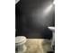 A dark bathroom featuring a toilet, vanity sink, and tile flooring at 10953 Winter Crest Dr, Riverview, FL 33569