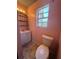 Pink-themed bathroom features a vanity, mirror, toilet, shelving, and a window with natural light at 10953 Winter Crest Dr, Riverview, FL 33569