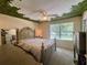 Cozy bedroom featuring unique tree design on the ceiling, large bed, and a bright window at 10953 Winter Crest Dr, Riverview, FL 33569