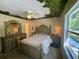 Bright bedroom featuring a large window, detailed furniture, and unique leaf-themed ceiling art at 10953 Winter Crest Dr, Riverview, FL 33569