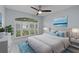 Bright bedroom featuring a large window with white shutters and a ceiling fan at 13038 Royal George Ave, Odessa, FL 33556
