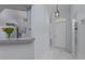 Light and airy entryway featuring marble floors, a modern light fixture, and view into the kitchen at 13038 Royal George Ave, Odessa, FL 33556