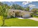 Charming single-story home with a well-manicured lawn, lovely landscaping and a brick paved driveway leading to a two-car garage at 13038 Royal George Ave, Odessa, FL 33556