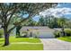 Charming single-story home with a well-manicured lawn, lovely landscaping and a brick paved driveway leading to a two-car garage at 13038 Royal George Ave, Odessa, FL 33556