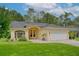Charming home with manicured lawn, arched entry, paver driveway, and attached two-car garage at 13038 Royal George Ave, Odessa, FL 33556
