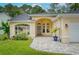 Well-kept home with manicured lawn, arched entrance, and a lovely paved driveway and walkway at 13038 Royal George Ave, Odessa, FL 33556