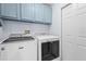 Well-lit laundry room featuring a Maytag washer and dryer set with overhead storage cabinets at 13038 Royal George Ave, Odessa, FL 33556