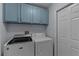 Laundry room features a side-by-side washer and dryer with upper storage cabinets at 13038 Royal George Ave, Odessa, FL 33556