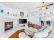 Spacious living room with a cozy fireplace, modern ceiling fan, and adjacent breakfast bar at 13038 Royal George Ave, Odessa, FL 33556