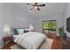 Bedroom with slider to the patio, ceiling fan, wood floors and ensuite bathroom at 13038 Royal George Ave, Odessa, FL 33556