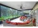 Enjoy this screened patio featuring a hot tub, comfortable seating, and a view of the backyard at 13038 Royal George Ave, Odessa, FL 33556