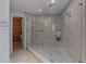 Large glass enclosed shower with bench, river rock floor and multiple shower heads at 13038 Royal George Ave, Odessa, FL 33556