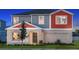 Charming two-story home with a gray and orange exterior, and a well-manicured lawn at 13040 Wellspring Dr, Lithia, FL 33547