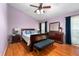 Bedroom featuring hardwood floors, lavender walls, ceiling fan, and a coordinating furniture set at 1308 Peachfield Dr, Valrico, FL 33596