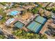 Aerial view of a community park featuring tennis courts, basketball courts, and a playground surrounded by mature trees at 1308 Peachfield Dr, Valrico, FL 33596