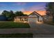 Charming single-Gathering home boasts stone accents, manicured lawn, two-car garage, and lovely twilight sky at 1308 Peachfield Dr, Valrico, FL 33596