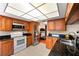 Kitchen features stainless steel appliances, dark countertops, wood cabinets, and white tile flooring at 1308 Peachfield Dr, Valrico, FL 33596