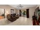 Inviting living room with tile floors, a brown leather sectional, and sliding glass doors at 1308 Peachfield Dr, Valrico, FL 33596