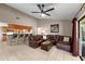Open-concept living room with tile floors, a leather sectional, a bar-style countertop, and ceiling fan at 1308 Peachfield Dr, Valrico, FL 33596