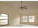 Bright bedroom with vaulted ceiling, ceiling fan and view to front yard through large window at 13218 Parkhurst Ct, Riverview, FL 33569