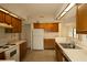 Functional kitchen featuring wood cabinets, tiled floor, and essential appliances for easy meal preparation at 13218 Parkhurst Ct, Riverview, FL 33569