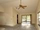 Bright living room featuring a ceiling fan, neutral walls, and sliding glass doors at 13218 Parkhurst Ct, Riverview, FL 33569