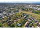 Expansive aerial view of a residential area with lush greenery, community pool, and well-maintained landscaping at 1390 Oak Hill Dr # 206, Dunedin, FL 34698
