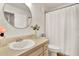 Clean bathroom with a round mirror, single sink vanity, and shower-tub combination at 1390 Oak Hill Dr # 206, Dunedin, FL 34698