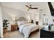 Comfortable bedroom with a ceiling fan, bedside lamps, and a mirror reflecting the bathroom at 1390 Oak Hill Dr # 206, Dunedin, FL 34698