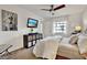 Bright bedroom featuring a wall-mounted TV, ceiling fan, and natural light from the window at 1390 Oak Hill Dr # 206, Dunedin, FL 34698