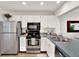 Well-lit kitchen featuring stainless steel appliances and a seamless connection to the dining area at 1390 Oak Hill Dr # 206, Dunedin, FL 34698