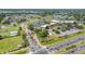An aerial view showcasing community entrance with clubhouse, lake, and golf course at 1416 Leland Dr # 49, Sun City Center, FL 33573